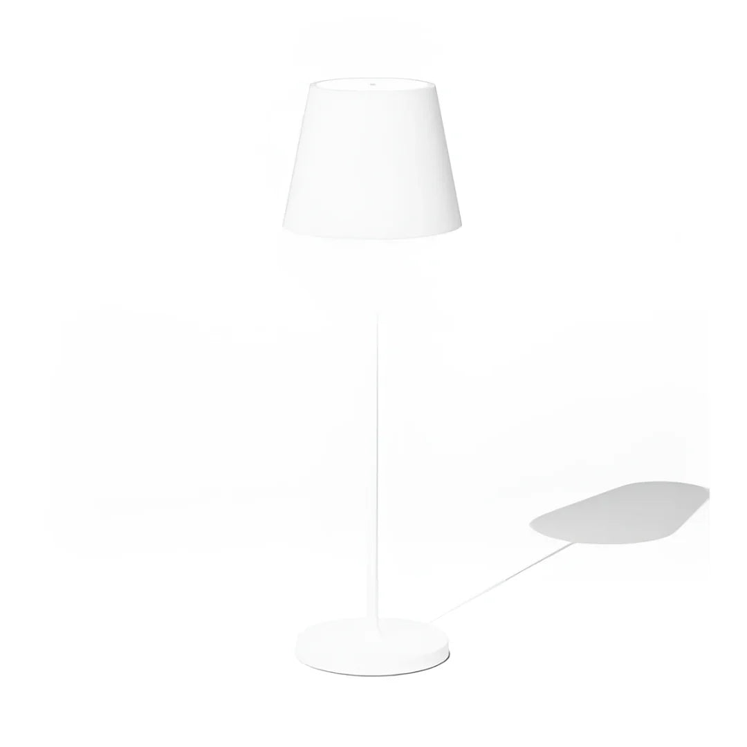 Modern wireless white table lamp with a conical shade, standing on a circular base, casting a subtle shadow on a white background.