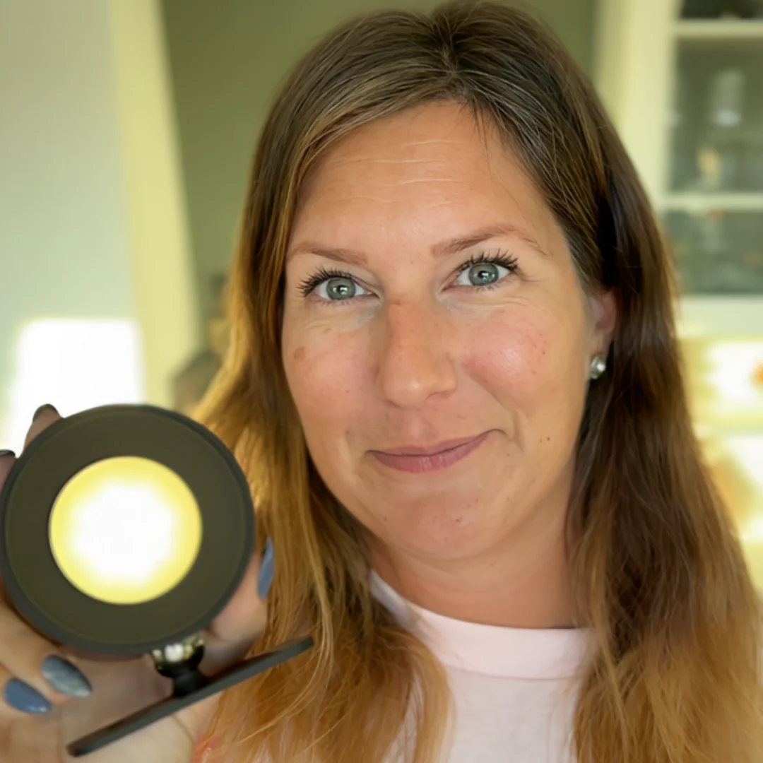 Woman holding a round wall light with a blurred background