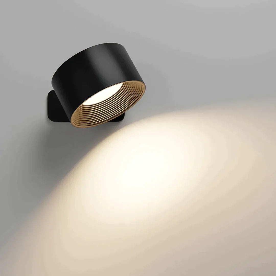 A stylish black wall lamp directs warm light onto a gray wall, enhancing the ambiance with a soft glow and modern design.