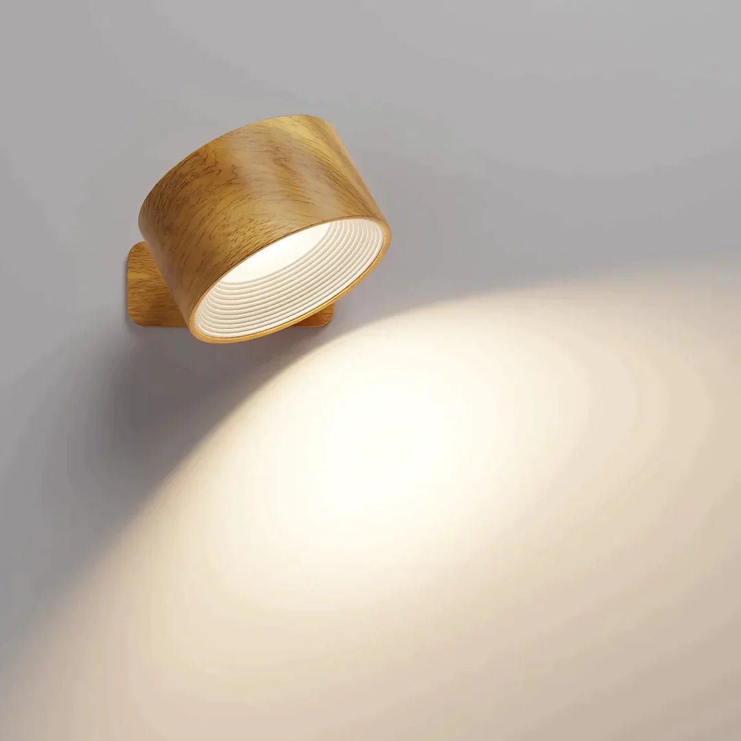 A stylish wooden wall lamp directs warm light onto a gray wall, enhancing the ambiance with a soft glow and modern design.
