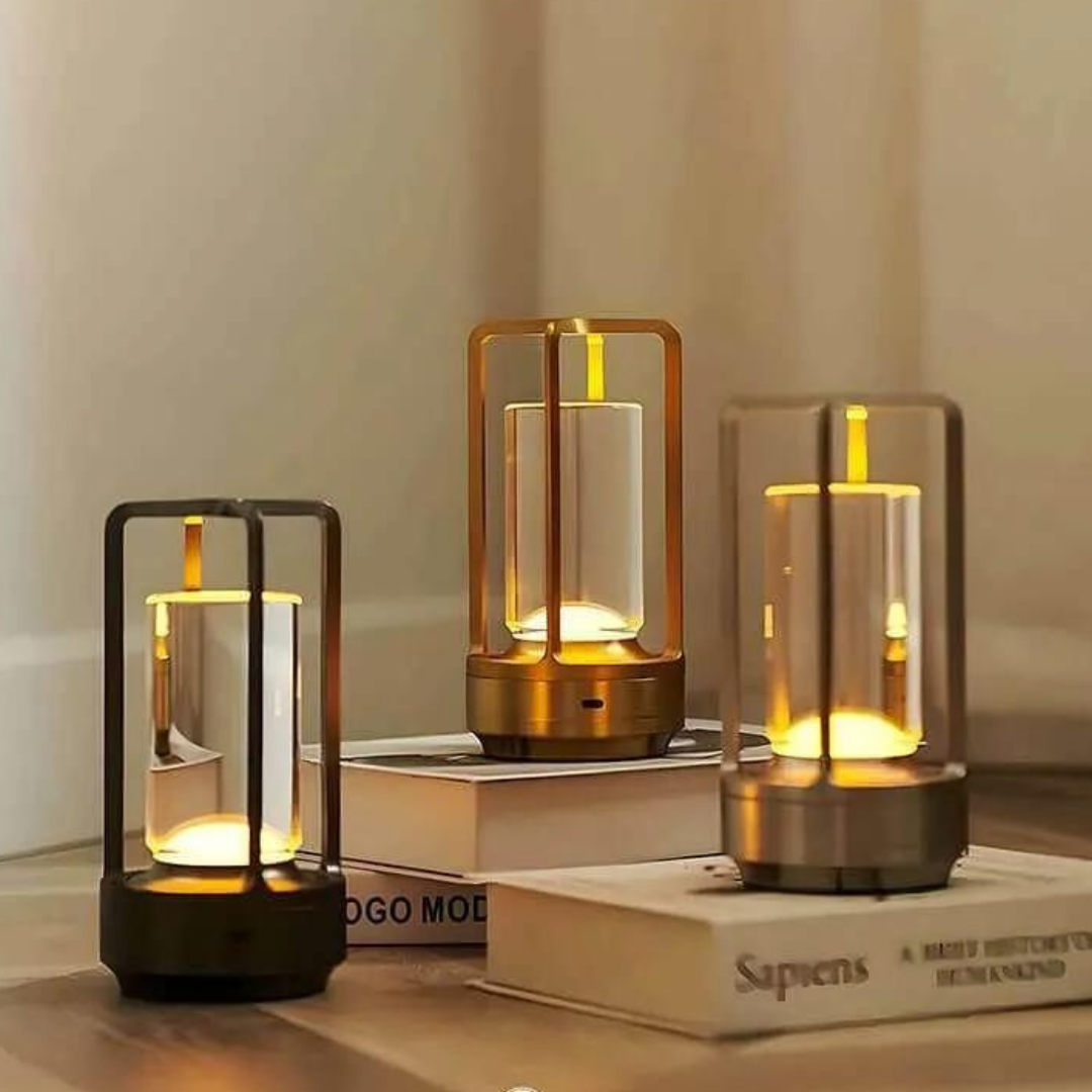 Three stylish wireless table lanterns with warm LED glow sit on stacked books, creating a cozy, inviting atmosphere in a modern setting.