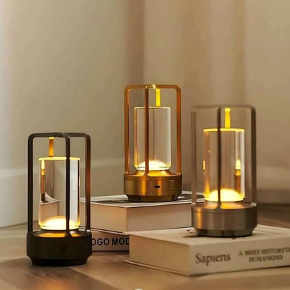 Three stylish wireless table lanterns with warm LED glow sit on stacked books, creating a cozy, inviting atmosphere in a modern setting.