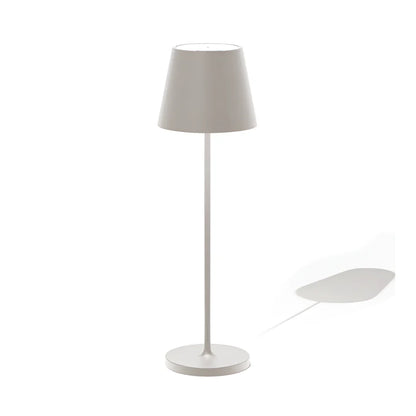 Modern wireless light gray table lamp with a conical shade, standing on a circular base, casting a subtle shadow on a white background.
